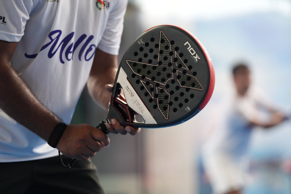 Close-up of a NOX padel racket held by a player